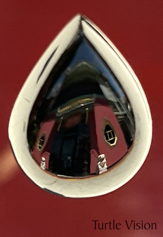 Mirror finished jade, 17mm tall black jade teardrop. Reflection of a building in China Town, Los Angles, California.